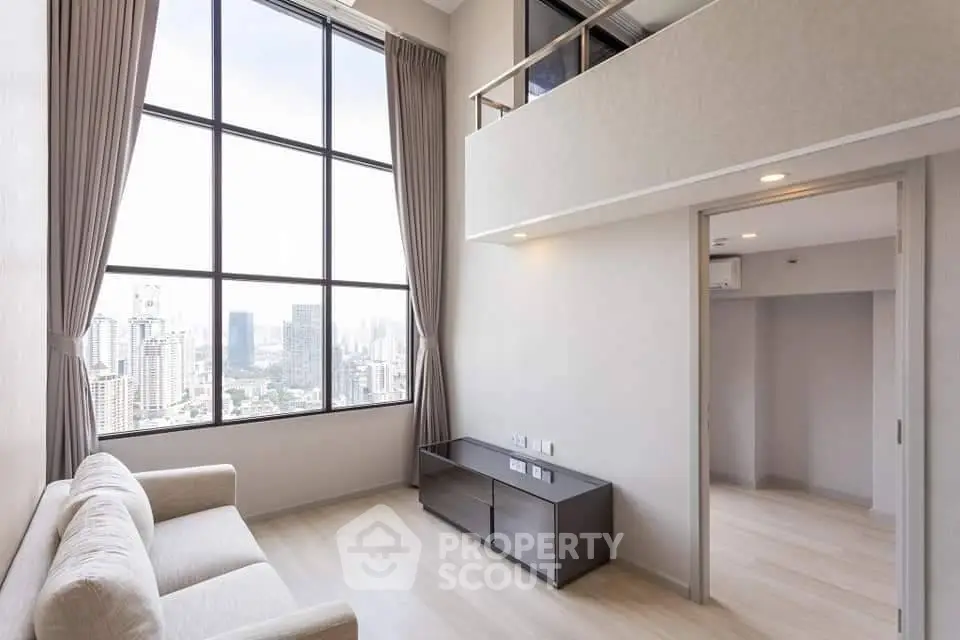 Spacious modern living room with high ceilings and city view, featuring large windows and elegant decor.