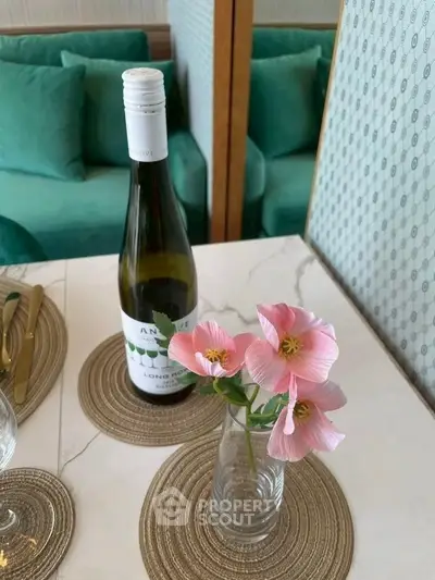 Chic dining setup with wine and flowers on elegant table in modern living room.