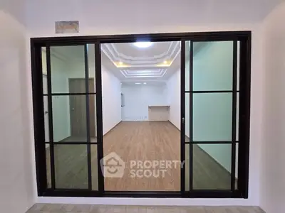 Spacious modern living room with elegant wooden flooring and sliding glass doors.