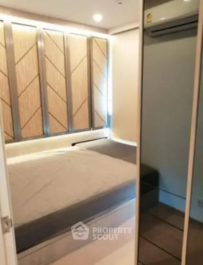 Modern bedroom with stylish paneling and mirrored closet doors.