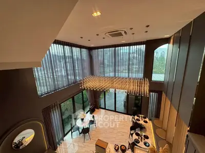 Luxurious modern living room with high ceilings and elegant lighting in a spacious open layout.