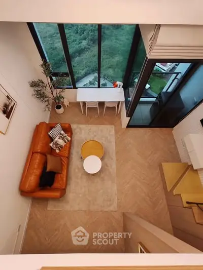 Modern living room with large windows and stylish furniture, offering a stunning view.