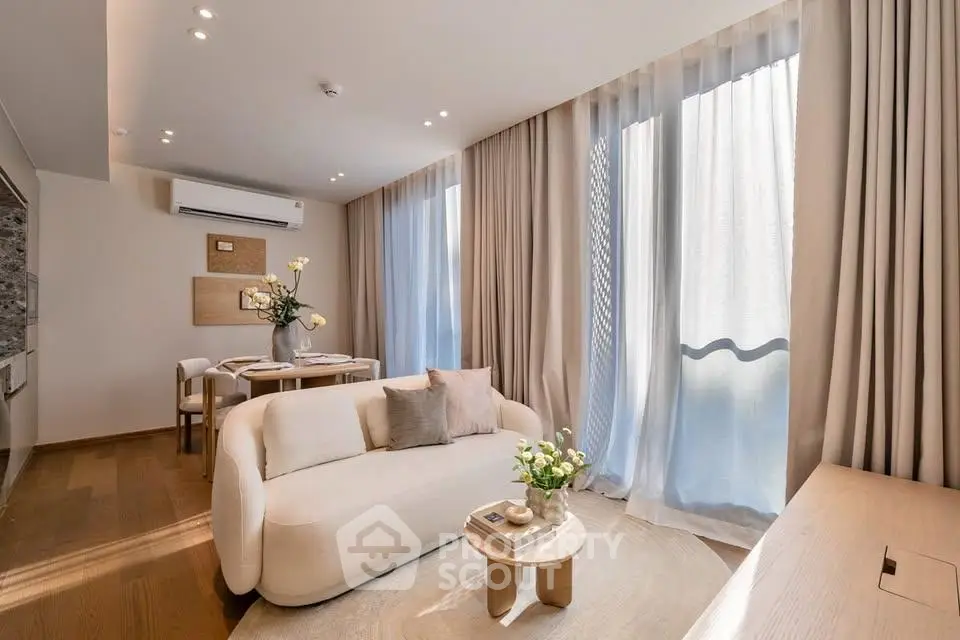 Elegant living room with modern decor, large windows, and cozy seating area in a stylish apartment.