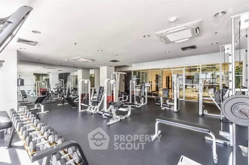 Spacious modern gym with state-of-the-art equipment in luxury residential building.