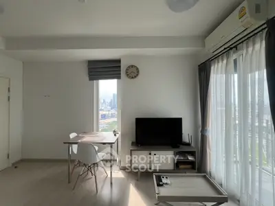 Modern living room with city view, featuring sleek furniture and abundant natural light.