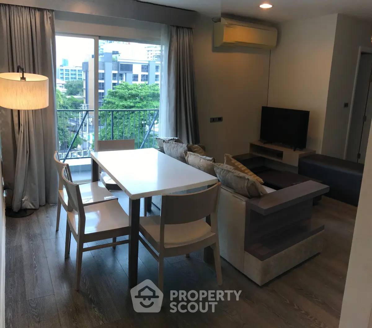 Modern living room with balcony view, featuring stylish furniture and natural light.