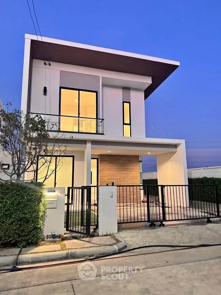 Modern two-story house with sleek design and large windows at dusk