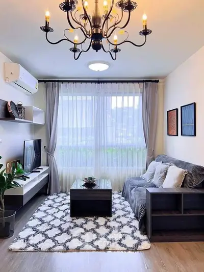 Stylish living room with modern decor, cozy seating, and elegant chandelier lighting.