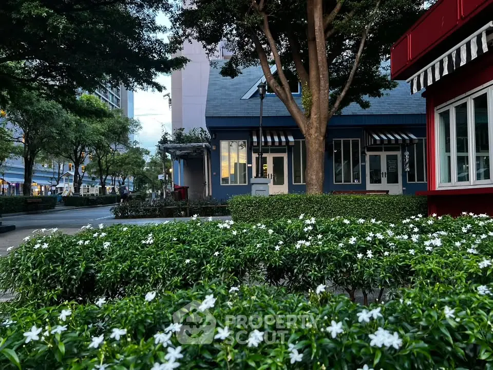 Charming urban garden with lush greenery and modern building facade, perfect for serene city living.