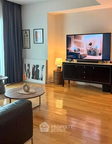 Stylish living room with wooden flooring, modern decor, and large TV setup for entertainment.