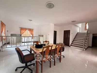 Spacious open-plan living area with elegant staircase and natural light