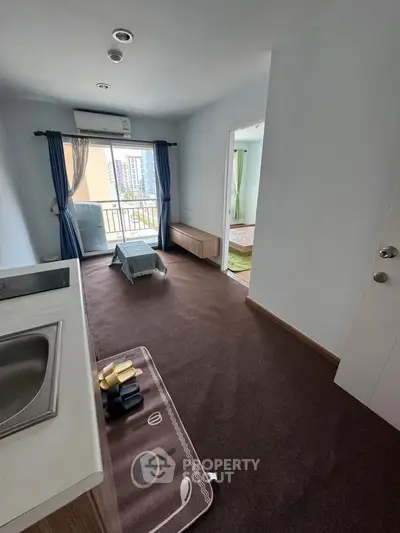 Cozy apartment with open layout, featuring a compact kitchen and bright living area with balcony access.