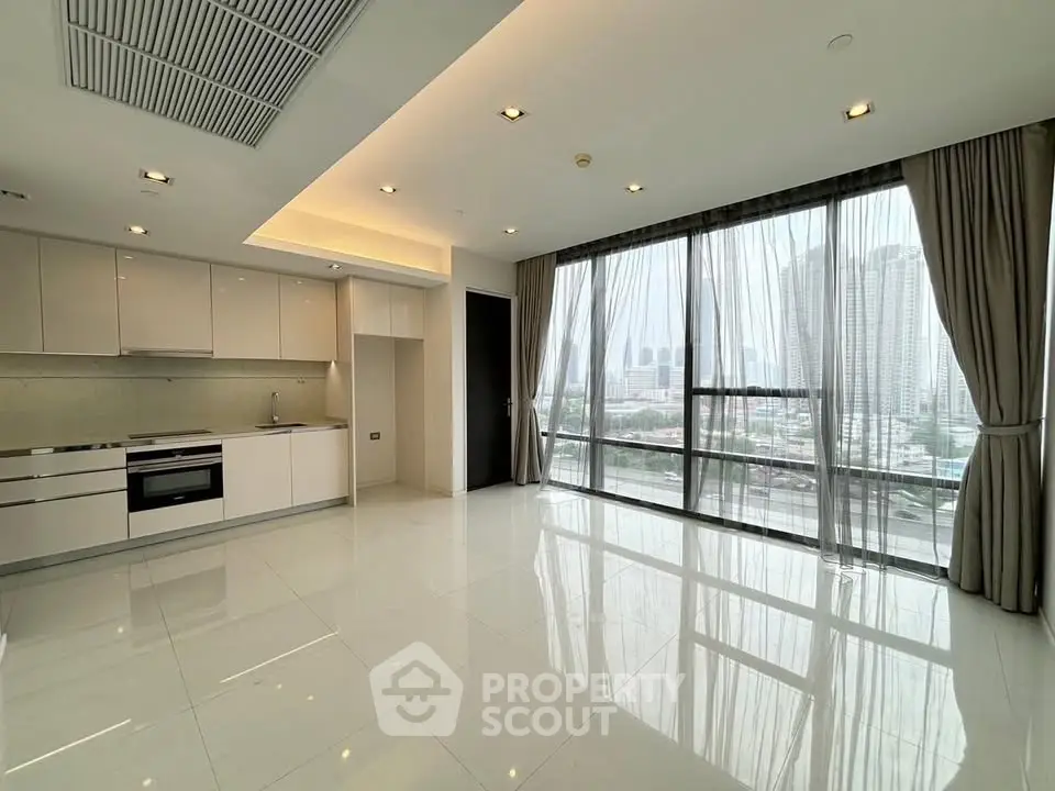 Spacious modern living room with open kitchen and panoramic city view.