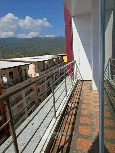 Scenic balcony view with mountain backdrop in modern apartment complex.