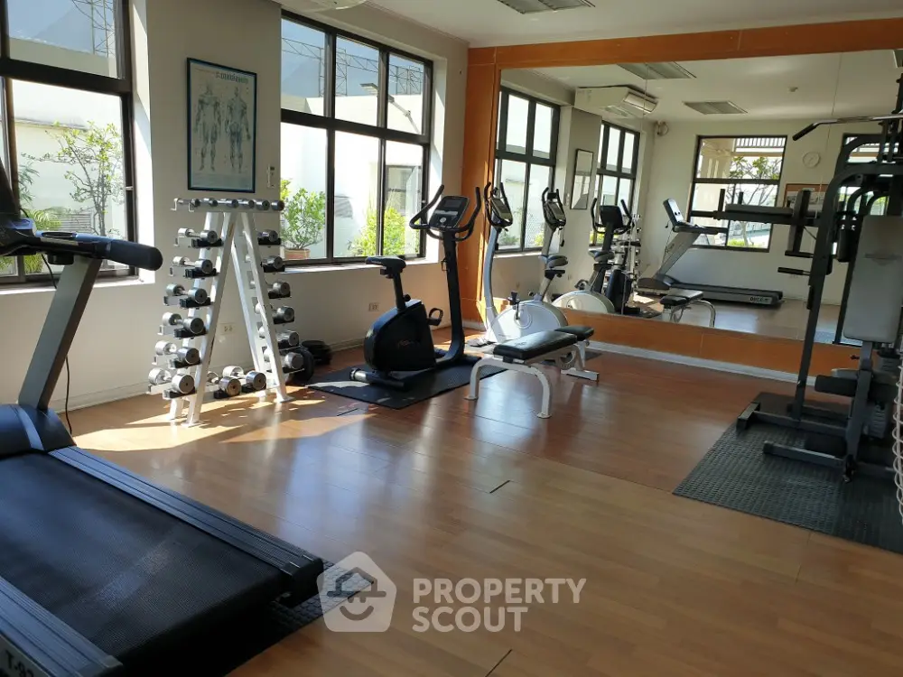 Spacious home gym with modern exercise equipment and large mirrors
