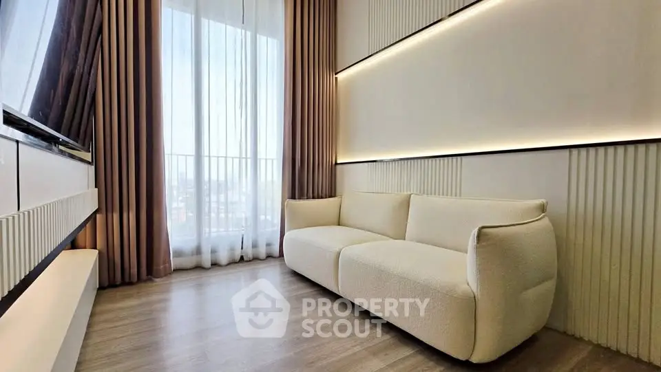 Modern living room with elegant sofa and floor-to-ceiling windows offering city views.