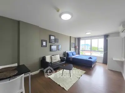 Modern studio apartment with stylish decor and large windows offering natural light and city views.