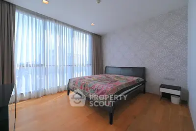 Spacious bedroom with large windows and elegant decor