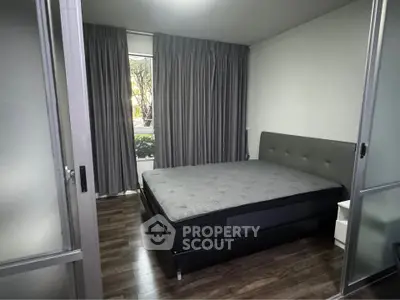 Modern bedroom with sleek design and large window for natural light.