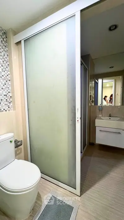 Modern bathroom with sliding frosted glass door and sleek vanity