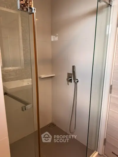 Modern bathroom with sleek glass shower enclosure and contemporary fixtures