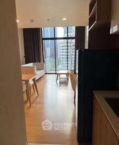Modern living room with city view, wooden flooring, and stylish furniture in a high-rise apartment.