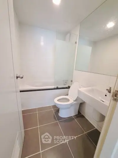 Modern bathroom with sleek design, featuring a bathtub and contemporary fixtures.