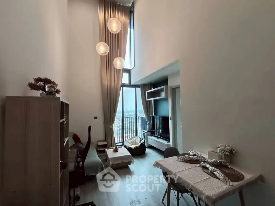Spacious modern living room with high ceilings and large windows offering a stunning view.