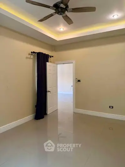Spacious room with ceiling fan and elegant lighting, perfect for versatile living space.