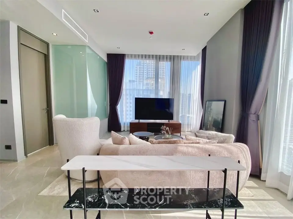 Luxurious modern living room with floor-to-ceiling windows and elegant furnishings in a high-rise apartment.