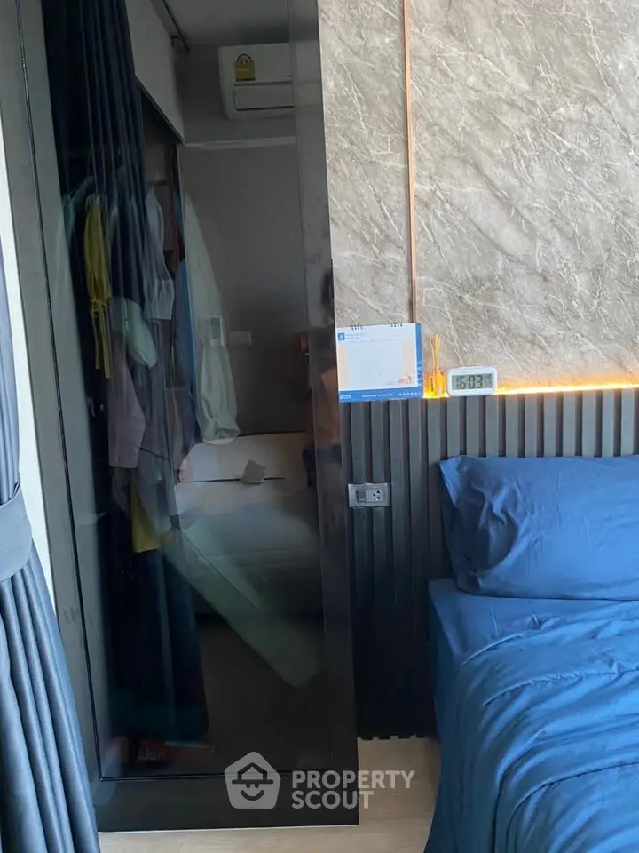 Modern bedroom with stylish decor and built-in closet, featuring elegant lighting and cozy bedding.