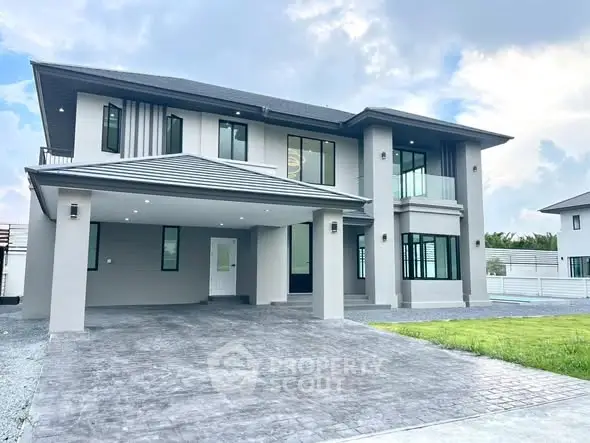 Stunning modern two-story house with spacious driveway and lush green lawn.