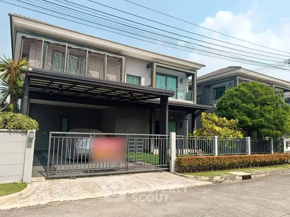 Modern two-story house with carport and lush greenery in a serene neighborhood.