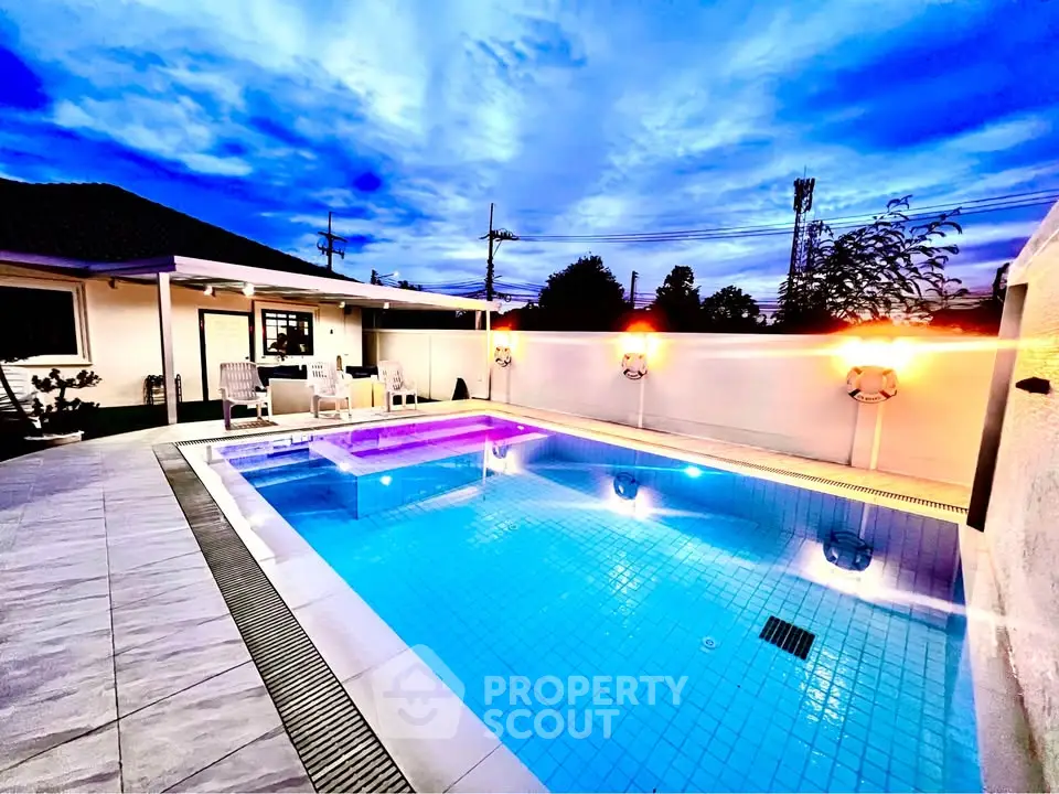 Stunning evening view of a luxurious private pool with ambient lighting and modern patio.