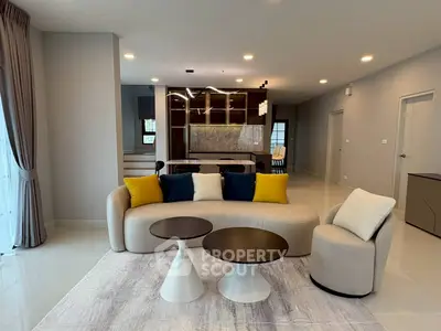 Modern living room with stylish furniture and open layout, featuring elegant lighting and neutral tones.