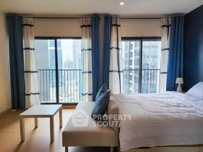 Modern bedroom with city view and large windows in high-rise apartment