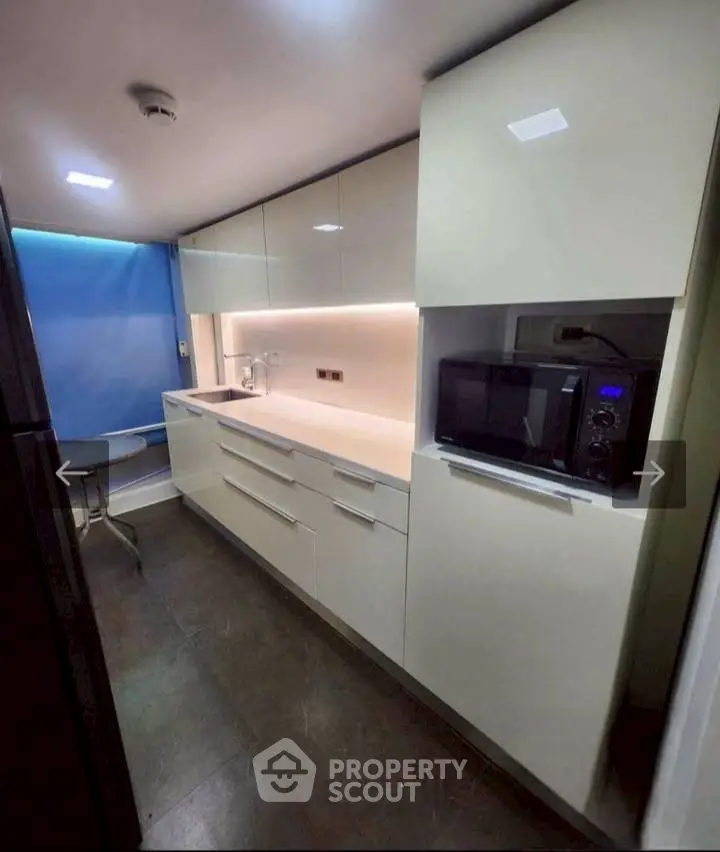 Modern kitchen with sleek cabinetry and built-in microwave, perfect for urban living.