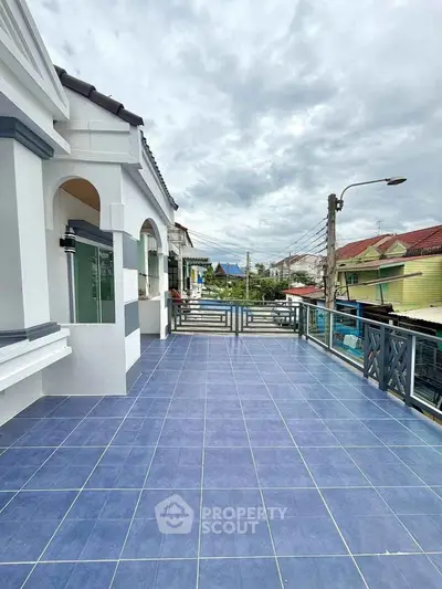 Spacious blue-tiled balcony with scenic neighborhood view