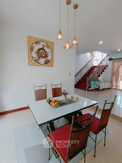 Elegant dining area with stylish decor and modern lighting in a spacious open-plan living room.