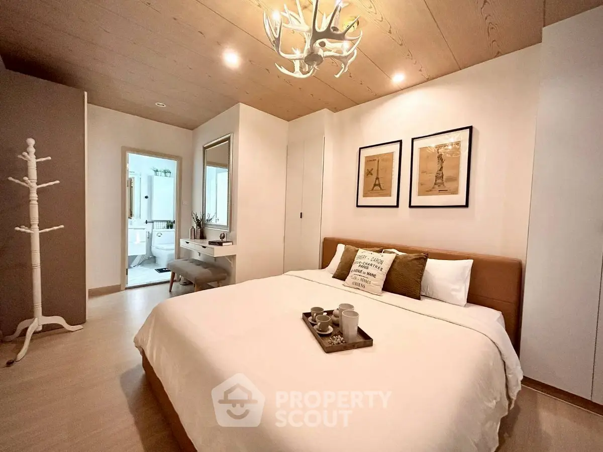 Cozy bedroom with modern decor and ensuite bathroom, featuring stylish lighting and warm wooden accents.