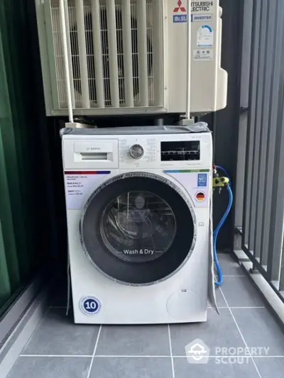 Modern Bosch washing machine on balcony with air conditioning unit above.