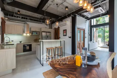 Stunning modern kitchen with open layout and industrial design, featuring high ceilings and natural light.