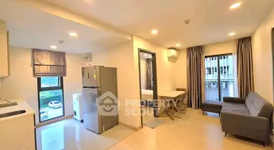 Modern open-plan apartment with kitchen, living area, and natural light.