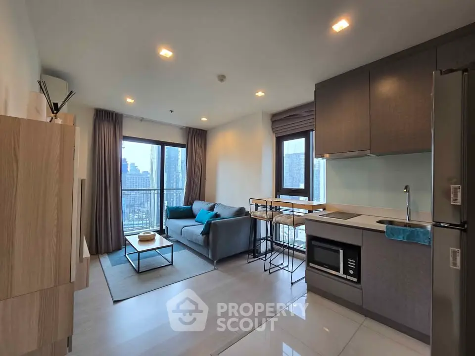 Modern open-layout living room with kitchen, city view, and stylish furnishings.
