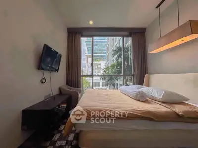 Modern bedroom with large window and city view, featuring a wall-mounted TV and stylish lighting.