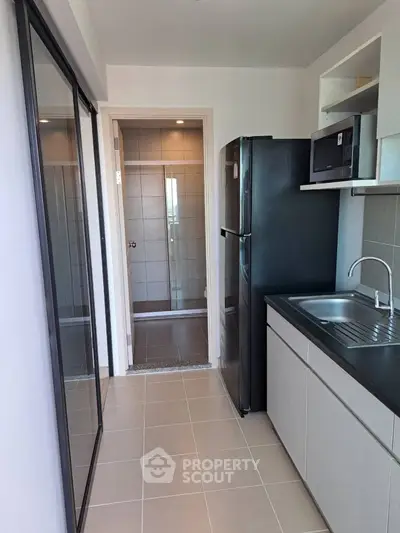 Modern kitchen with sleek appliances and ample storage in a contemporary apartment.