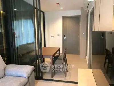 Modern apartment interior with cozy dining area and stylish glass partition.