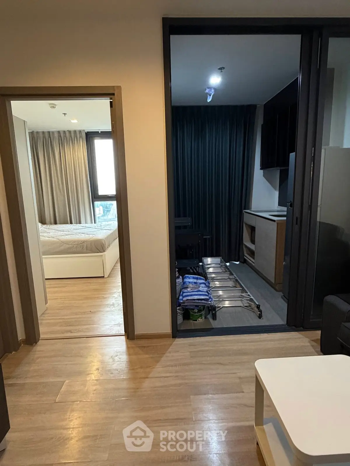 Modern apartment interior with bedroom and living area, featuring sleek design and natural light.