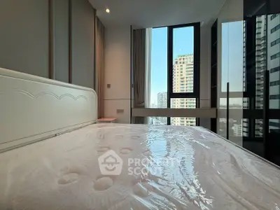 Modern bedroom with large windows offering stunning city views in a high-rise apartment.