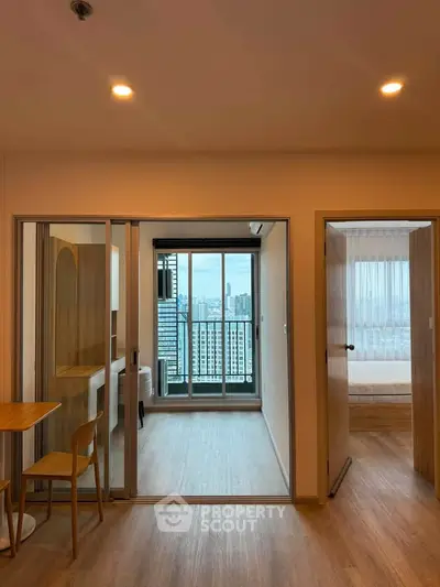 Modern apartment interior with city view, featuring open layout and wooden flooring.
